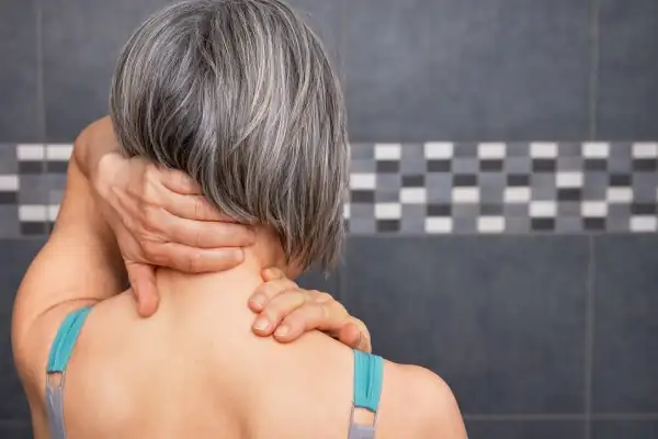 Femme pratiquant l'automassage du visage et de la nuque pour soulager le stress