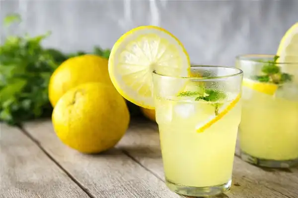 Jus de citron frais pressé dans un verre d'eau, avec tranches de citron